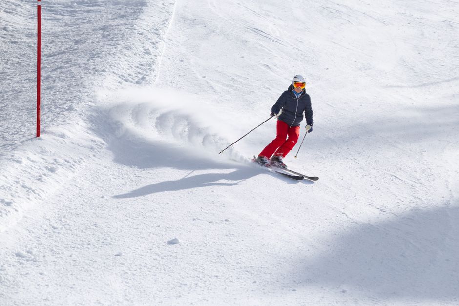 A skier carving through deep powder snow