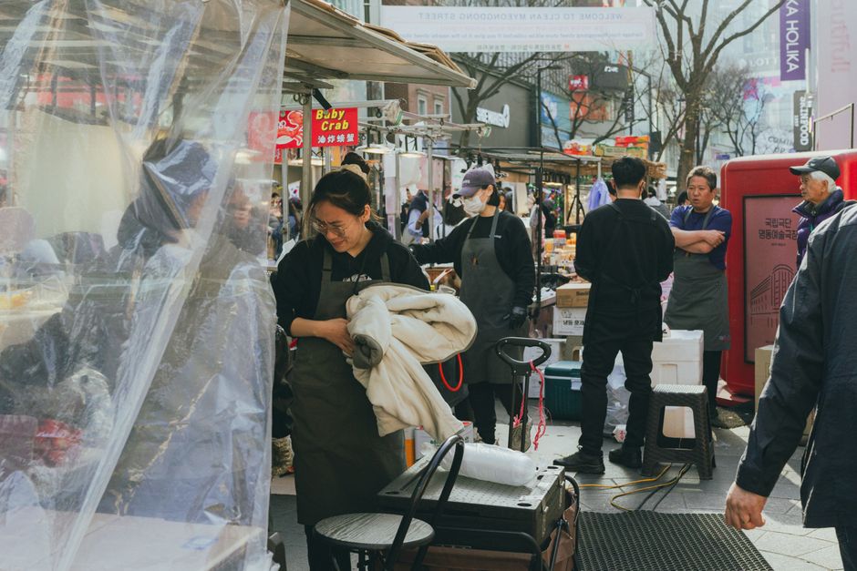 Gwangjang Market Seoul food hall with bindaetteok pancake stalls and crowds