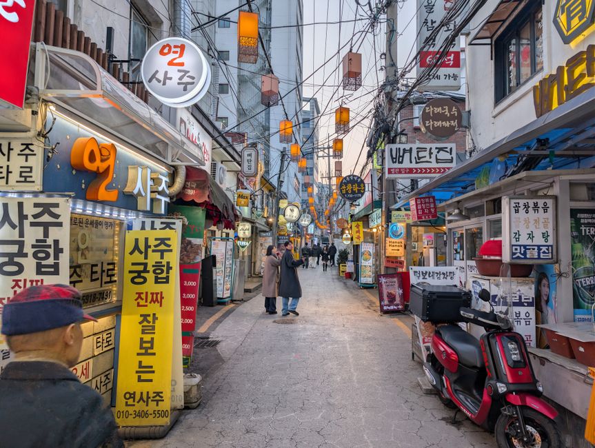 Ikseondong hanok alley evening with lantern lights and pedestrians